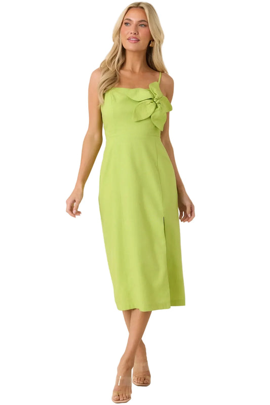Woman wearing a green dress with a bow detail on a beige background