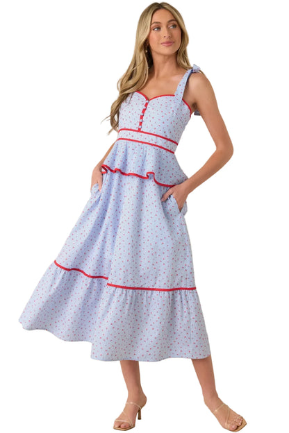 Woman wearing a light blue dress with red accents on a beige background