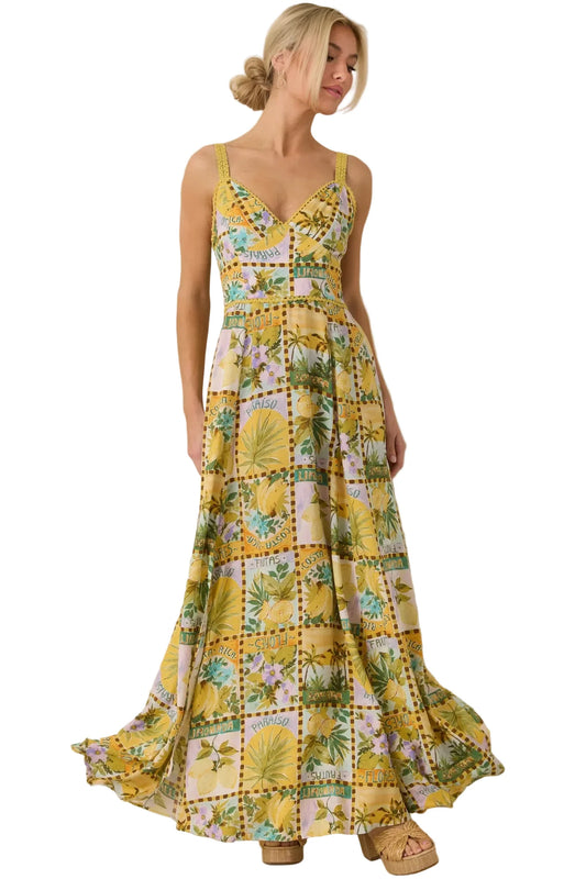Woman wearing a yellow floral dress against a beige background