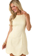 Woman wearing a light yellow dress against a beige background